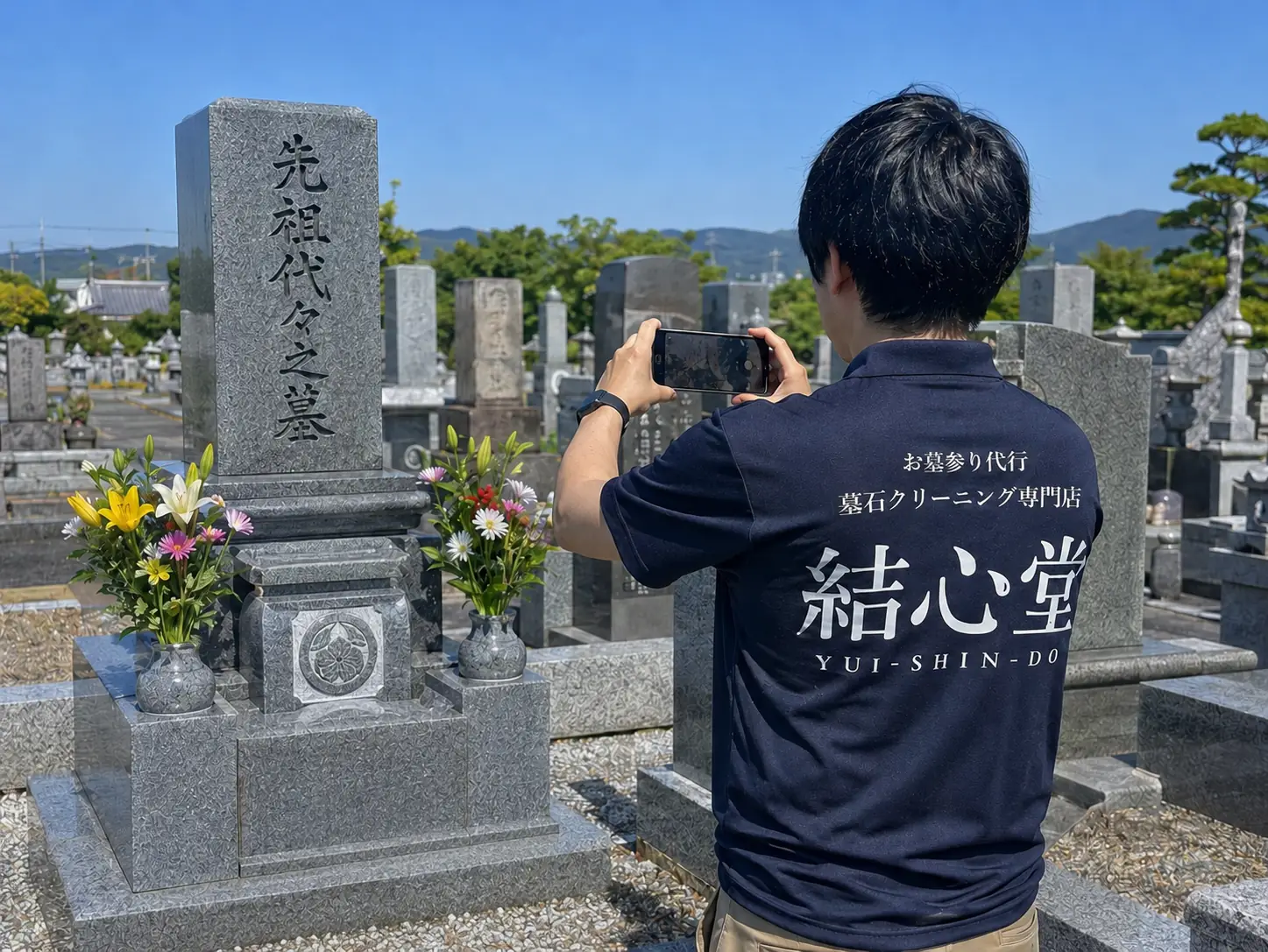 お墓の写真を撮影するスタッフ